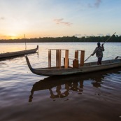 Coucher de soleil en Guyane. Sur le fleuve Maroni. Pirogue transportant du mobilier contemporain DISSI en bois massif de Guyane.