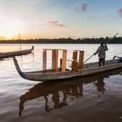 Coucher de soleil en Guyane. Sur le fleuve Maroni. Pirogue transportant du mobilier contemporain DISSI en bois massif de Guyane.