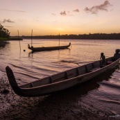 Coucher de soleil en Guyane. Sur le fleuve Maroni. Pirogue et enfant sur la pirogue.