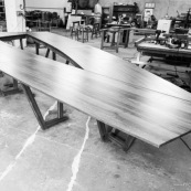 Atelier d'un artisan menuisier en train de réaliser une grande table de réunion en bois massif de Guyane.