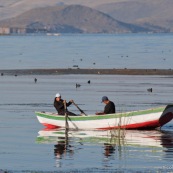 Lac  Titicaca,  barque de peche sur le lac avec pecheur. Pérou. A la rame. Peche traditionnelle. Femme et homme.  Perou.