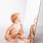 Portrait de bebe avec un miroir. Il se regarde dans la glace.