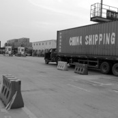 Camion porte container avec inscription "China Shipping" (transport chinois)  dans le port de Shenzhen, un des plus grands ports du monde.
Fabrication chinoise, usine du monde. Camion, transport de marchandises routier, avant le transport maritime. Asie.