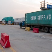 Camion porte container avec inscription "China Shipping" (transport chinois)  dans le port de Shenzhen, un des plus grands ports du monde.
Fabrication chinoise, usine du monde. Camion, transport de marchandises routier, avant le transport maritime. Asie.