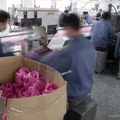 Usine chinoise de fabrication de rollers. Ouvriers a la chaine, en train d'assembler des pieces plastiques de rollers (cuffs roses) sur tapis roulant. Chine, Shenzhen, usine du monde. Travail plus de 70 heures par semaine, a faible couts, pour utilisation des produits par les pays "riches".