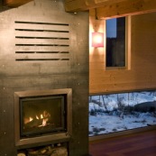 Poele à bois dans un chalet de montagne. Contraste entre le feu et la neige à l'extérieur. Chalet en bois, moderne. En soirée. Chauffage. Insert. Dans les cévennes, mont aigoual.