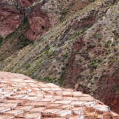 Terrasses des salineras de Maras. Une personne remplie des sacs de sel. Exploitation de sel. L'eau d'une source riche en sel est guidée dans les terrasses, l'eau s'évapore, reste le sel. Balcons. Pérou.