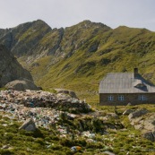 Refuge de montagne de Turnuri, avec au premier plan un tas de dechets. Montagnes en arriere plan. Veritable decharge, cela gache honteusement le paysage. Poubelles entassees devant le refuge, pollution en montagne. Roumanie.