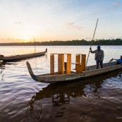 Coucher de soleil en Guyane. Sur le fleuve Maroni. Pirogue transportant du mobilier contemporain DISSI en bois massif de Guyane.