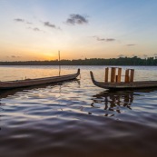 Coucher de soleil en Guyane. Sur le fleuve Maroni. Pirogue transportant du mobilier contemporain DISSI en bois massif de Guyane.