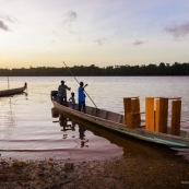 Coucher de soleil en Guyane. Sur le fleuve Maroni. Pirogue transportant du mobilier contemporain DISSI en bois massif de Guyane.