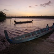 Coucher de soleil en Guyane. Sur le fleuve Maroni. Pirogue et enfant sur la pirogue.