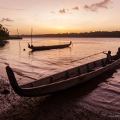 Coucher de soleil en Guyane. Sur le fleuve Maroni. Pirogue et enfant sur la pirogue.