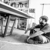 Atelier d'un artisan menuisier en train de réaliser une grande table de réunion en bois massif de Guyane.