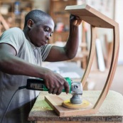 Artisan menuisier en train de réaliser du mobilier en bois massif de Guyane pour la marque DISSI.