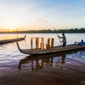 Coucher de soleil en Guyane. Sur le fleuve Maroni. Pirogue transportant du mobilier contemporain DISSI en bois massif de Guyane.