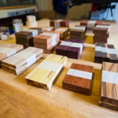 Echantillons de bois de Guyane sur une table.  Amarante, cèdre, balata, saint martin rouge, bagasse, bois seprent, boco, wacapou, manil, gaiac...