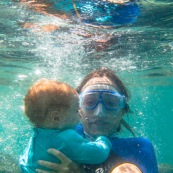 Guadeloupe. Tourisme. Femme et son bebe avec des lunettes. Sous l'eau.