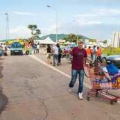 Crise sociale en Guyane. 11 avril 2017. Sur un barrage (rond-point Vidal, entre Cayenne et Rémire Montjoly. Les poids lourds bloquent toutes les routes. Impossible de passer (sauf piétons et vélos). Un homme vient de faire ses courses, à pied, dans la grande surface de l'autre coté du barrage (Carrefour Market), avec un cadie.