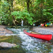 Canoes en Guyane, leve de soleil en foret tropicale amazonienne. Sur une crique (riviere). Passage d'un saut a la cordelle. Crique Memora.
