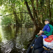 Kayak, kayaliste, en Guyane, foret tropicale amazonienne. Sur une riviere (crique). En bout de canoe.