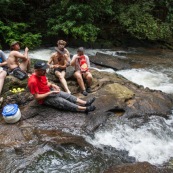 Expedition en Guyane (foret tropicale amazonienne) en canoe et kayak. Arret pic-nic en haut d'un saut (chute d'eau cascade). Camping, repas.