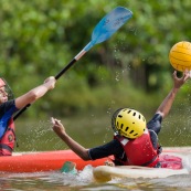 Kayak polo en Guyane, lac saccharin. Jeune jouant avec un ballon en kayak en exterieur. Pres du sentier du rorota a Remire Montjoly.