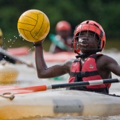 Kayak polo en Guyane, lac saccharin. Jeune jouant avec un ballon en kayak en exterieur. Pres du sentier du rorota a Remire Montjoly.