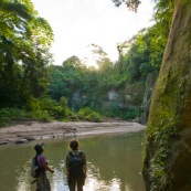 Guide bolivien et touriste au coucher de soleil dans un canyon du parc national Amboro. Pieds dans l'eau, randonnee. Bolivie.