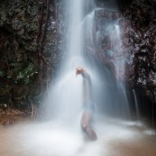 Homme sous une cascade en Guyane (Ouanary). Baignade.