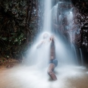 Homme sous une cascade en Guyane (Ouanary). Baignade.