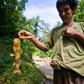 Pecheur avec une canne rudimentaire venant de pecher un petit poisson. Bolivie.