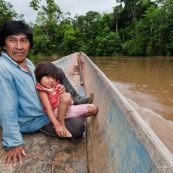 Amerindien dans une pirogue. Indigene Waorani (huaorani). Avec sa petite fille et sa sarbacane. Dans la foret tropicale amazonienne.