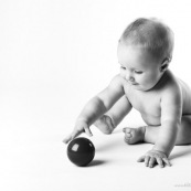 Bebe avec une balle rouge. Portrait.