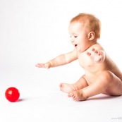 Bebe avec une balle rouge. Portrait.