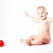 Bebe avec une balle rouge. Portrait.