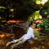 Guyane. Jeune fille enfant en train de se baigner dans une rivière (crique) en pleine foret (sentier du Rorota). Foret tropicale amazonienne.