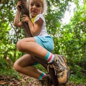 Guyane. Jeune fille enfant en train de grimper sur une liane en foret tropicale amazonienne.