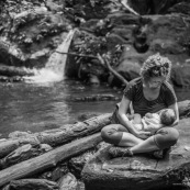 Touristes. Femme et son bebe en train d'allaiter. Allaitement maternel. En foret tropicale amazonienne.  Tourisme. Crique (riviere). Guyane.