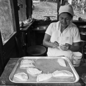 Femme en cuisine en train de cuisiner des empanadas.