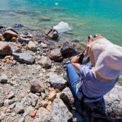 Touriste en train d'obeserver avec des jumelles au bord de l'eau, lac turquoise en Patagonie argentine.