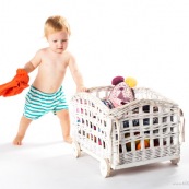 Bebe petite fille . Portrait. En train de s'amuser avec des vetements et un chariot. Habits. Enfant.