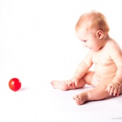 Bebe avec une balle rouge. Portrait.