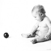 Bebe avec une balle rouge. Portrait.