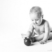 Bebe avec une balle rouge. Portrait.