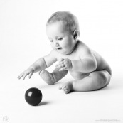 Bebe avec une balle rouge. Portrait.