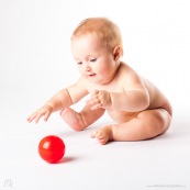 Bebe avec une balle rouge. Portrait.