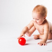 Bebe avec une balle rouge. Portrait.