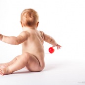 Bebe avec une balle rouge. Portrait.