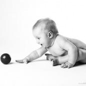 Bebe avec une balle rouge. Portrait.